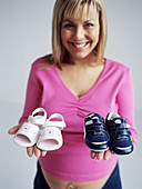 Pregnant woman with baby shoes