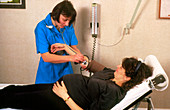 Nurse takes blood pressure in pregnancy