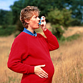 Pregnant woman using an inhaler to control asthma