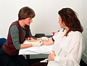 Doctor taking blood sample from a pregnant woman