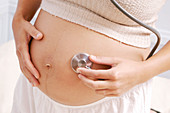 Pregnant woman using a stethoscope