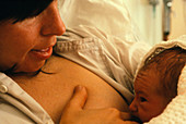 A mother breast-feeding her newly born son