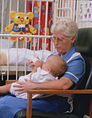 Nurse feeding baby in hospital