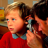 Doctor with otoscope to check child's ear