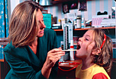 Doctor checking girl's throat for tonsillitis