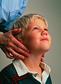 Doctor examines child's neck for swollen glands