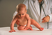 Doctor checking a baby's ability to crawl