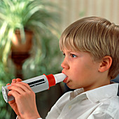 Lung function: boy breathes into peak flow meter