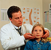 GP doctor examines young girl for swollen glands