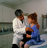 Doctor uses stethoscope to listen to girl's chest