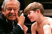 Paediatrician Dr Brazelton with boy and otoscope