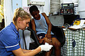 Nurse dressing child's leg wound