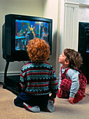 Children closely watching the TV