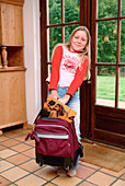 Girl lifting a suitcase