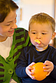 Toddler eating an orange