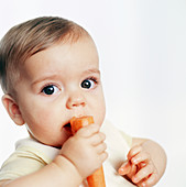 Baby boy eating a carrot