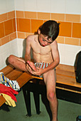 Young boy examines his foot at a swimming pool