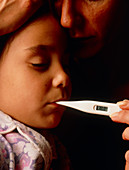 Young girl with fever has oral temperature taken