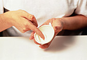 A spermicide foam being rubbed in a diaphragm