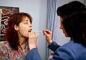 GP taking a throat swab from a patient
