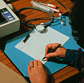 Doctor signing a computer-printed prescription
