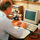 A GP writing a computer prescription