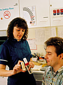 Nurse showing asthma patient inhaler & pk.flow mtr