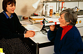 Doctor tests elderly patient with peak-flow meter