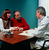 Middle-aged couple in consultation with GP doctor
