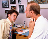 Doctor looking at lymph gland area of a man's neck