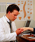 GP doctor examines a patient's hand for arthritis