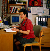 Female GP doctor sitting working at her desk