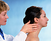 Female GP palpating the lymph glands of a woman