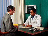 GP doctor writes a prescription for a male patient