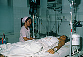 Nurse watches malaria patient in intensive care