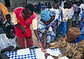 Health worker handing out an ivermectin tablet