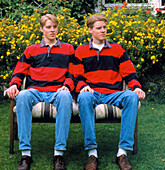 Twins dizygotic sitting on bench