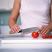 Woman cutting a tomato