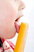 Toddler licking an ice lolly