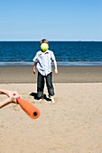 Boys playing with a bat and ball