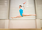 Gymnast jumping on a balance beam