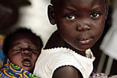 Ugandan girl carrying a baby