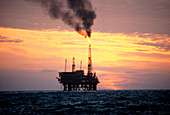Oil production platform in North Sea at sunset