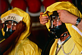Two workers being fitted with protective clothing