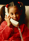 Young girl talks on a telephone