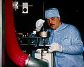 Worker adjusting glass blank for an optical fibre
