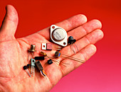 Hand holds transistors from the 1960s to 1990s