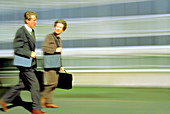 Business man and business woman walking in a hurry