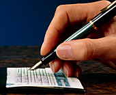 Hand writing a cheque with a fountain pen