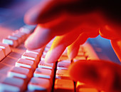 Close-up of a person typing on a computer keyboard